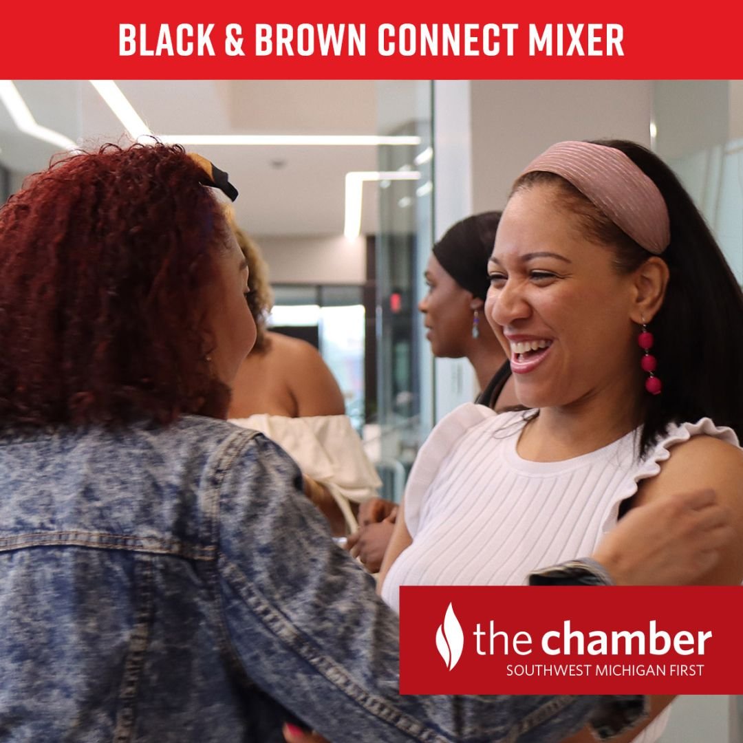 photo of two black women smiling and embracing one another at a Black & Brown Connect Mixer